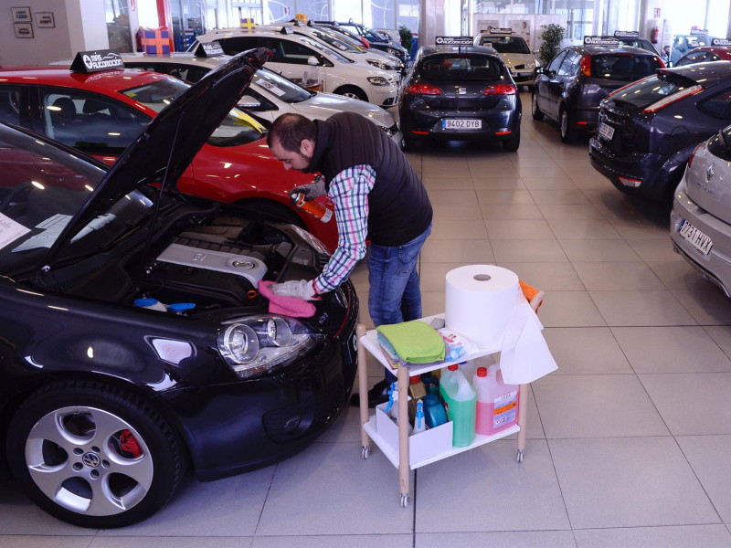 Un trabajador de un concesionario comprueba el motor de un vehículo