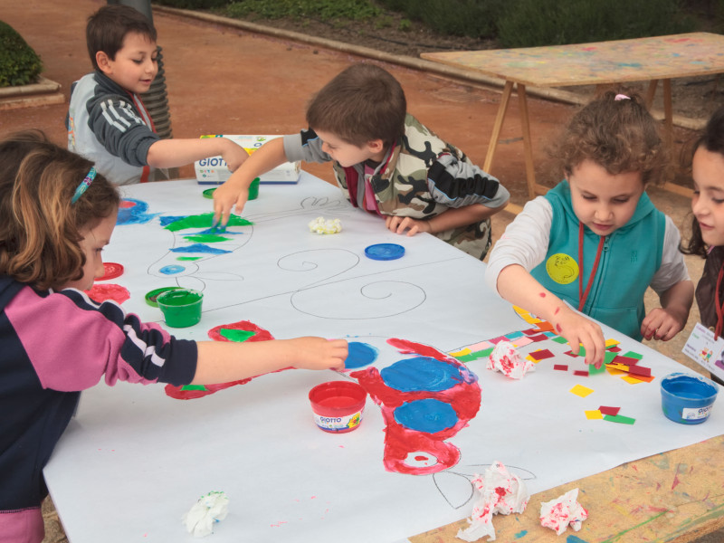 Niños de primaria disfrutando de una clase de arte al aire libre en los terrenos de la Huerta de San Vicente, Granada.