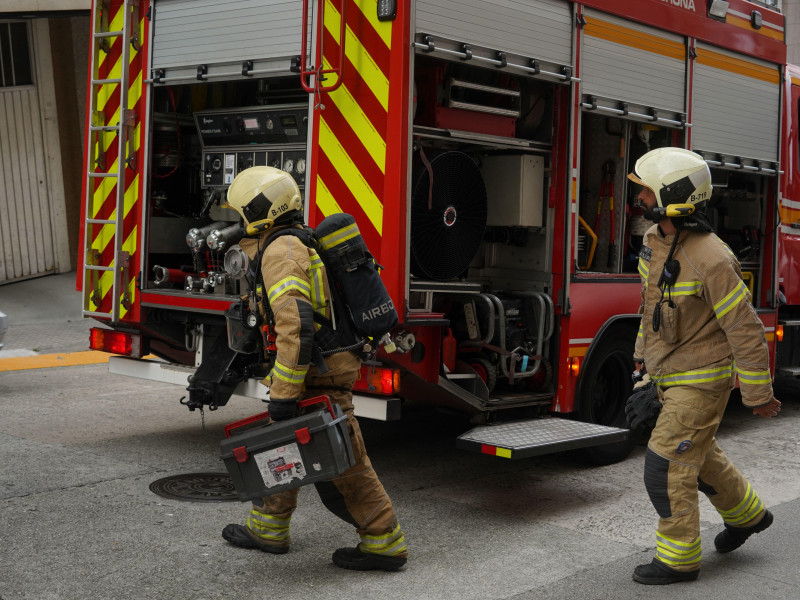 Los bomberos acuden en camión de bomberos para apagar un incendio en una casa.