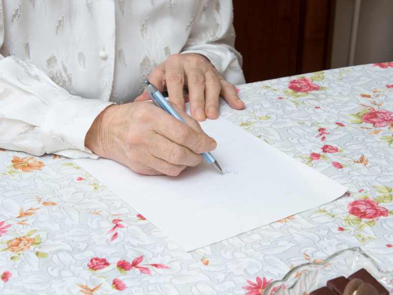 La anciana escribe un testamento manuscrito