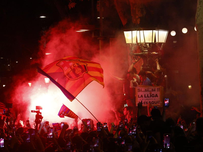 Aficionados del FC Barcelona celebran en la fuente de Canaletas el título de Liga conseguido por el equipo blaugrana tras derrotar al RCD Espanyol