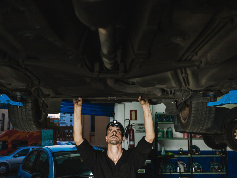 Mecánico examinando el coche en el taller
