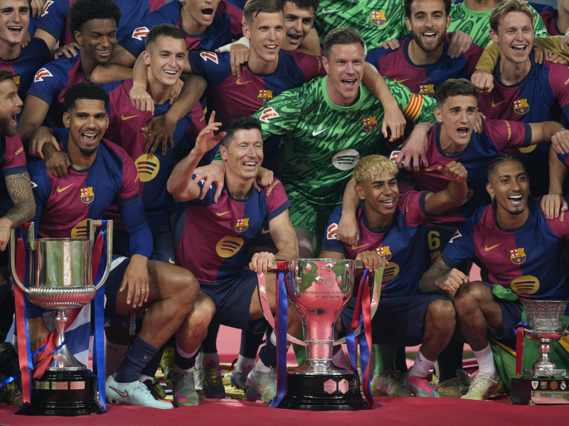 Los jugadores del Barcelona posan con los tres títulos ganados esta temporada
