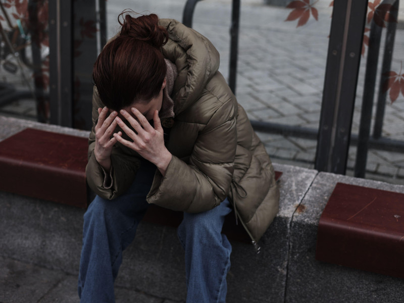 Una joven con dolor de cabeza se agarra la cabeza con migraña.