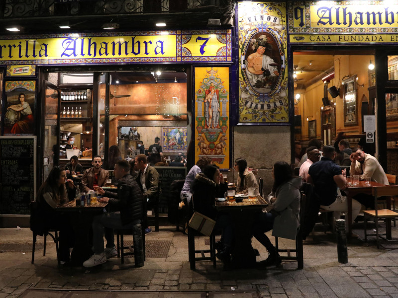 La gente disfruta de una bebida al aire libre en la terraza de un bar en el centro de Madrid.