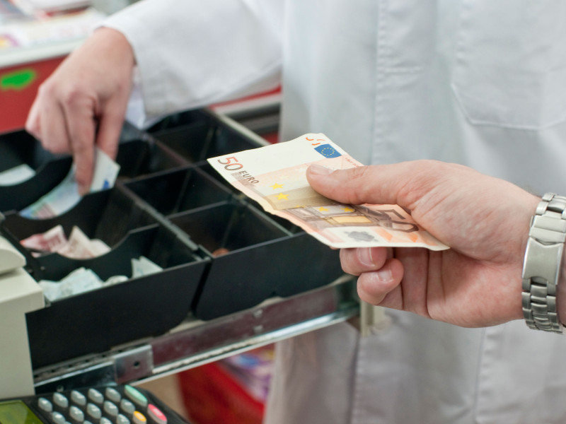 Efectivo en mano del cliente que paga en el supermercado