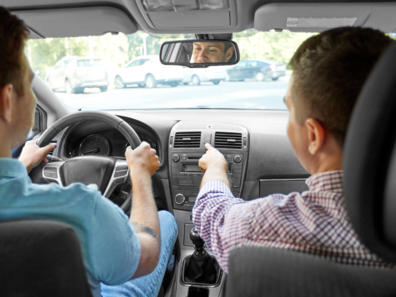 Un profesor de autoescuela da indicaciones a un alumno al volante