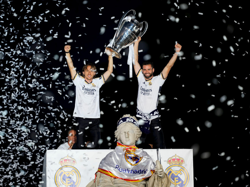 Nacho Fernández y Luka Modric del Real Madrid celebran en lo alto de la fuente con el trofeo en la Fuente de Cibeles durante la celebración del Real Madrid tras ganar su 15º título de la UEFA Champions League contra el Borussia Dortmund en Londres el 2 de junio de 2024, en Madrid.