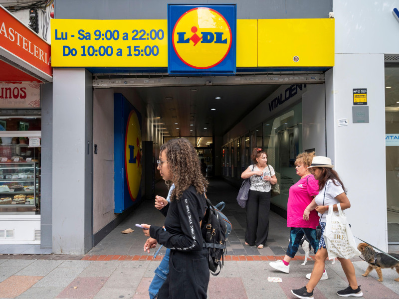 Los peatones pasan junto a la cadena internacional de supermercados de descuento alemana Lidl.