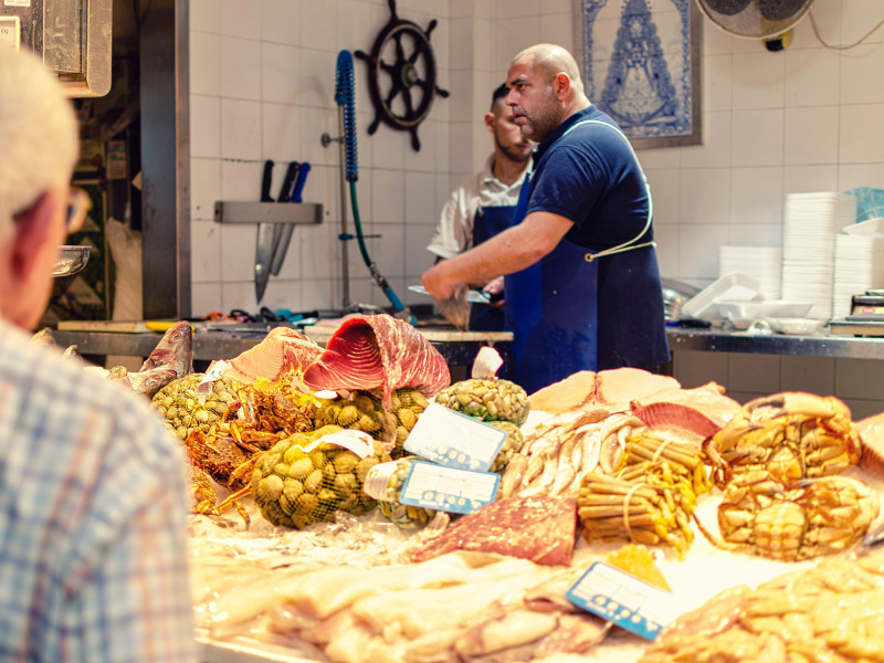 Pescadero en el mercado de Triana preparando pescado para un jubilado