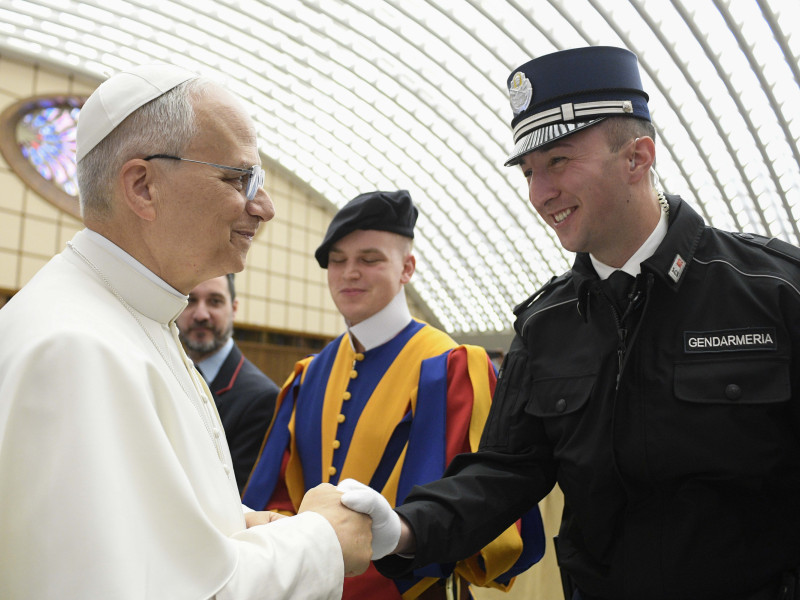 El papa León XIV saluda a un gendarme mientras preside una audiencia con la Curia romana y los empleados del Estado de la Ciudad del Vaticano este sábado.