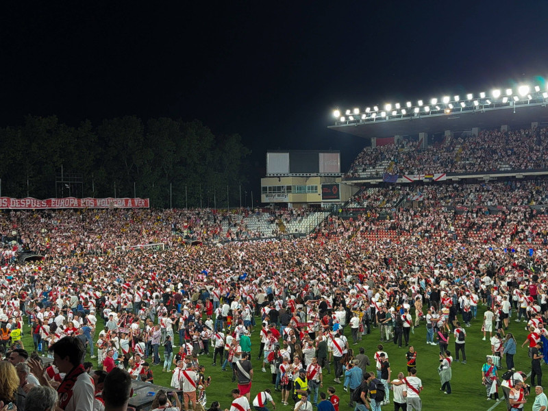 Los aficionados del Rayo celebran sobre el césped la clasificación europea del equipo.