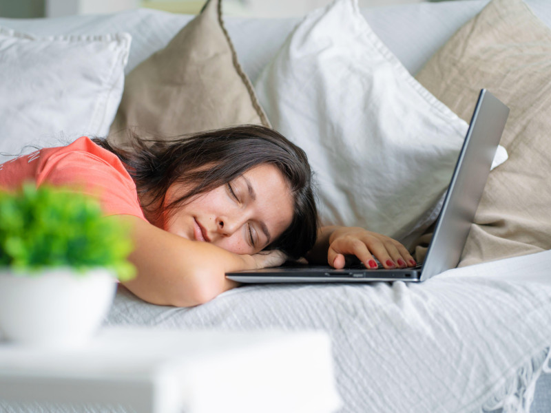 Una joven se quedó dormida sobre una computadora portátil mientras trabajaba.