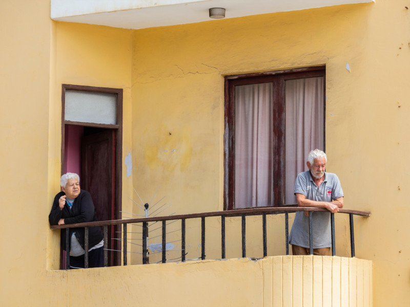 Una pareja de ancianos en el balcón de un edificio de apartamentos en España