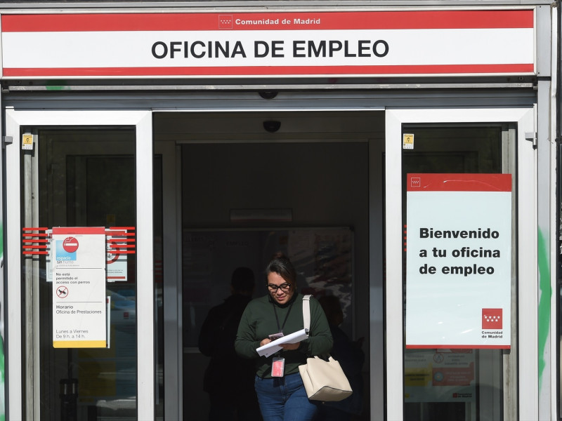 Una mujer sale de una oficina de empleo