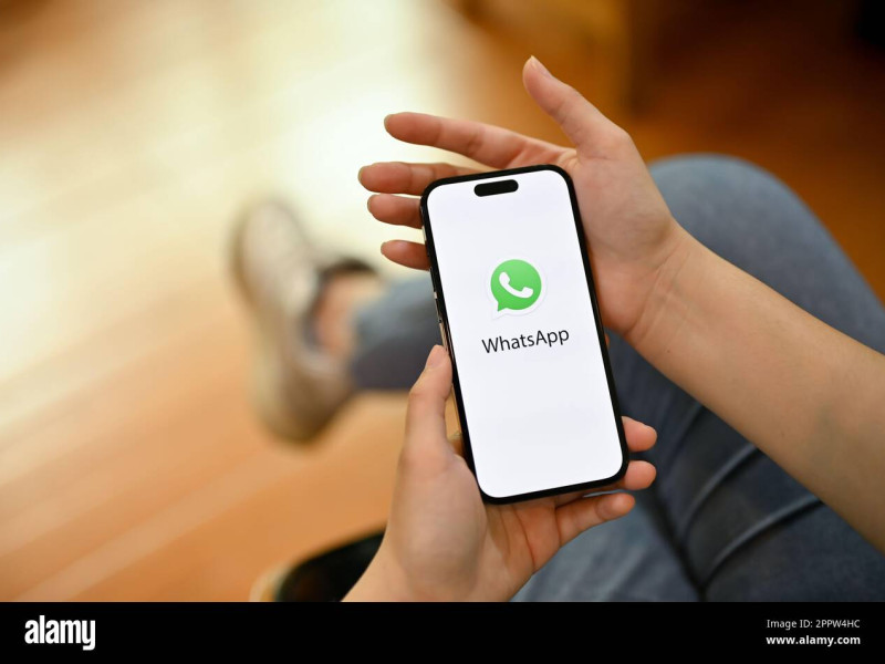 2PPW4HC 2PPW4HC Chiang Mai, Thailand - April 18 2023: A female using WhatsApp application on her phone. iPhone with WhatsApp logo on screen.