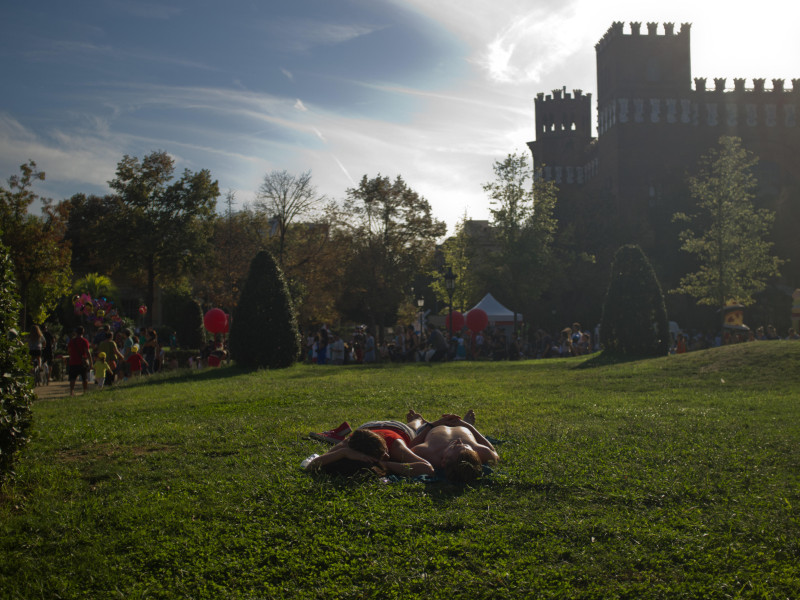 Una pareja descansa en el césped del Parque de la Ciutadella de Barcelona