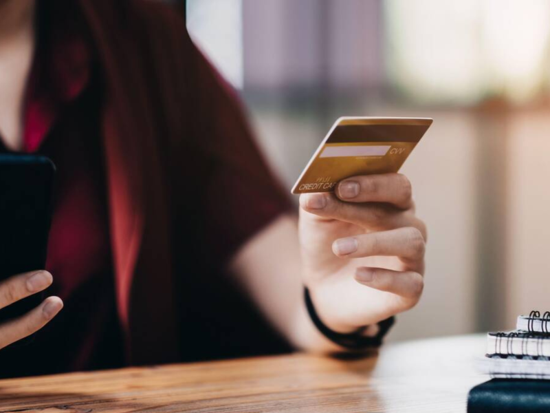 Una mujer utiliza su tarjeta de crédito para pagar una compra online con su móvil