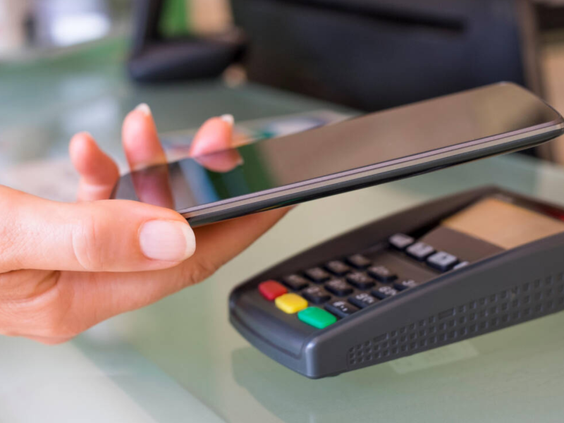 Una mujer pagando a través de su teléfono móvil con dinero digital