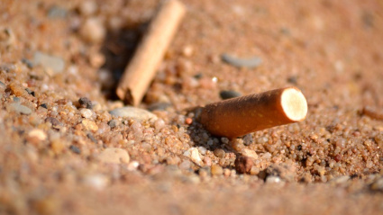 Colilla de un cigarro en la arena de una playa