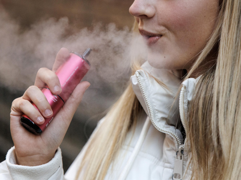 Una mujer echando humo consumiendo un vapeador