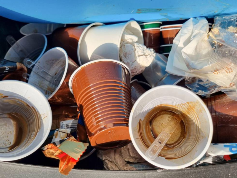 Vasos de plástico con diferentes líneas en la basura después de haber sido usados