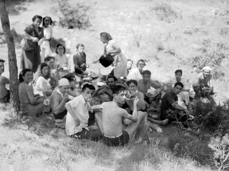 Miembros de una familia sevillana disfrutan de una comida campestre, años 50