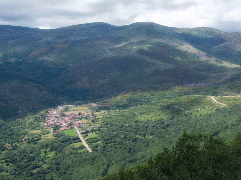 Vista aérea de un pequeño pueblo de Branosera rodeado de montañas cubiertas de vegetación.