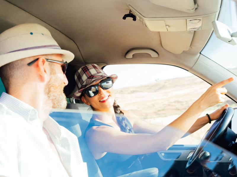 Pareja viajando en una camioneta señalando su próximo destino