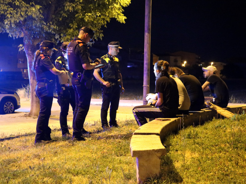 Agents dels Mossos i de la Policia Local de Mollerussa parlen amb un grup de joves.
