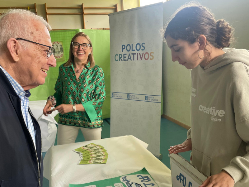Díaz Fierros escucha las explicaciones de una estudiante