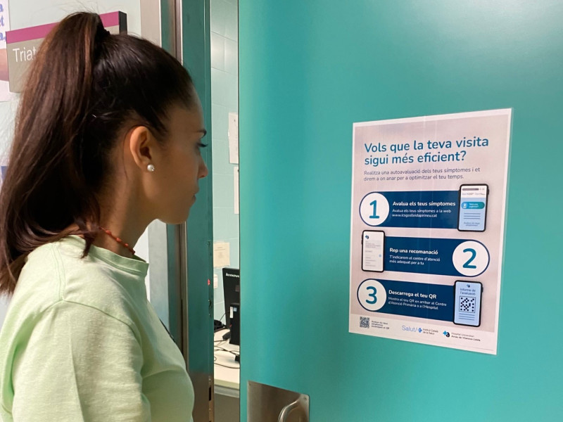 Usuària davant un cartell informatiu de l'aplicació