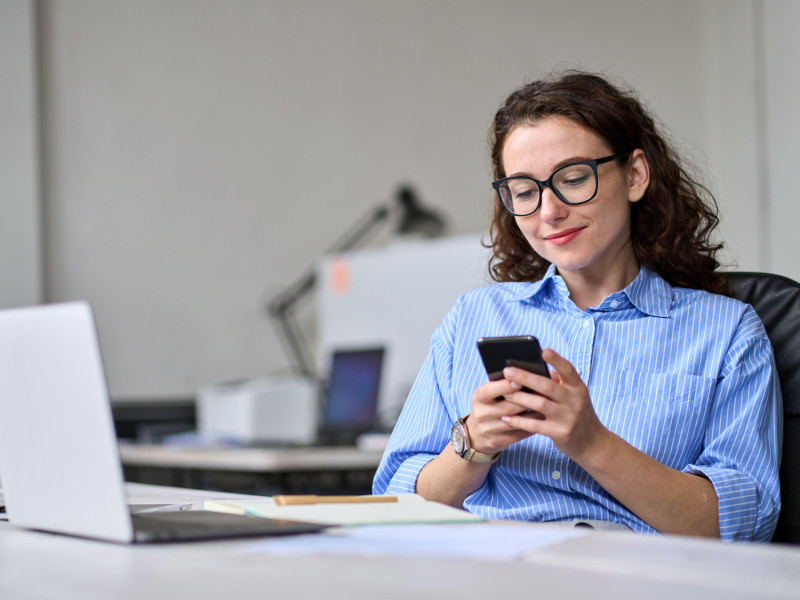 Mujer usando un teléfono móvil en el trabajo