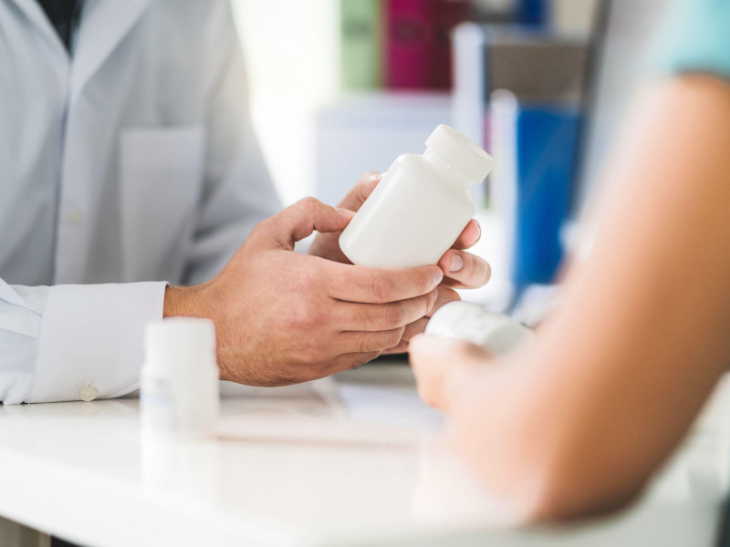 Un médico enseña un bote de medicamentos