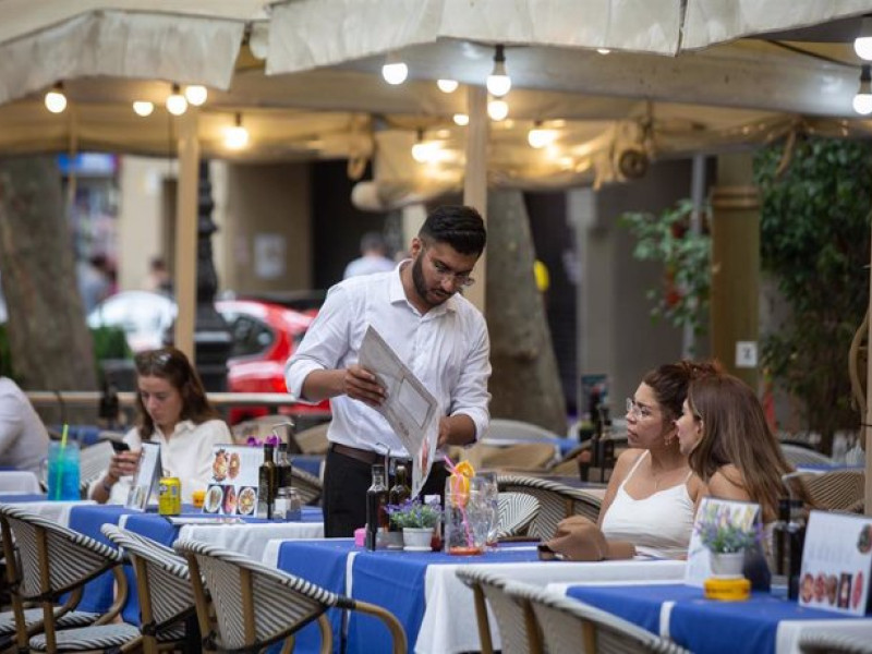 Camarero atiende a clientes en una terraza