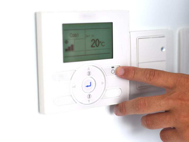 Un hombre ajusta la temperatura de la habitación