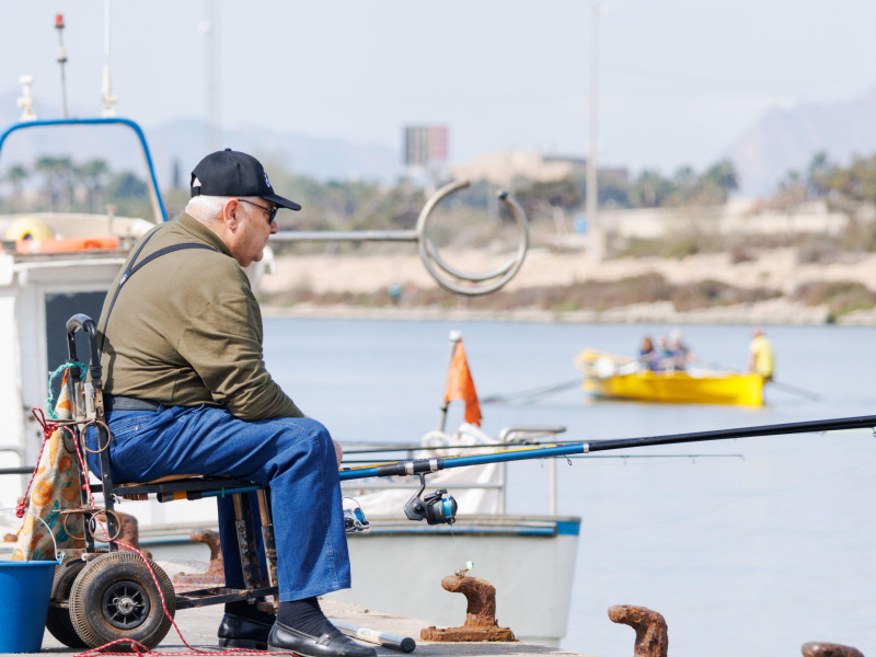 Anciano pescando en el puerto deportivo de Guardamar del Segura