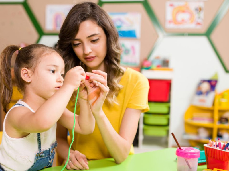 Una profesora junto a una alumna de infantil realizando un ejercicio