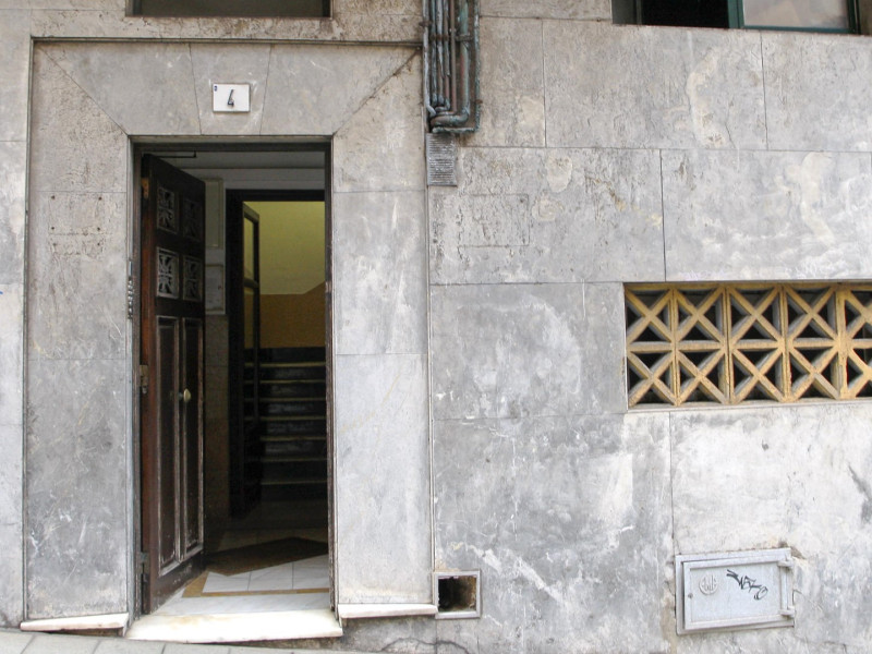 La puerta del edificio de Gijón en el que ha sido hallado el cadáver de una mujer