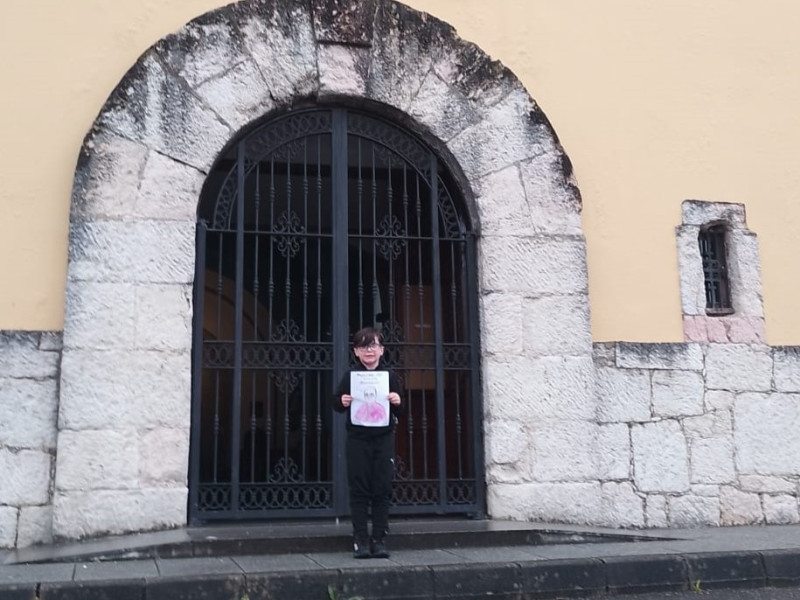 Uno de los niños de catecismo de la parroquia de San Félix de Lugones sostiene la carta enviada desde el Vaticano