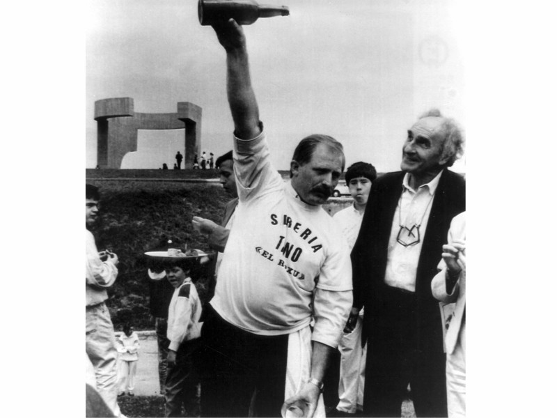 El hostelero Tino 'El Roxu' escancia un culín de sidra a Chillida en la inauguración del Elogio del Horizonte, en Gijón