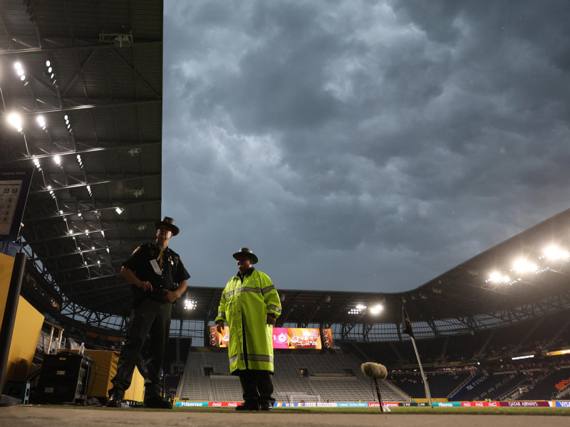 Integrantes de la Policía de Cincinnati se resguardan de la lluvia este miércoles durante el Mundial de Clubes.
