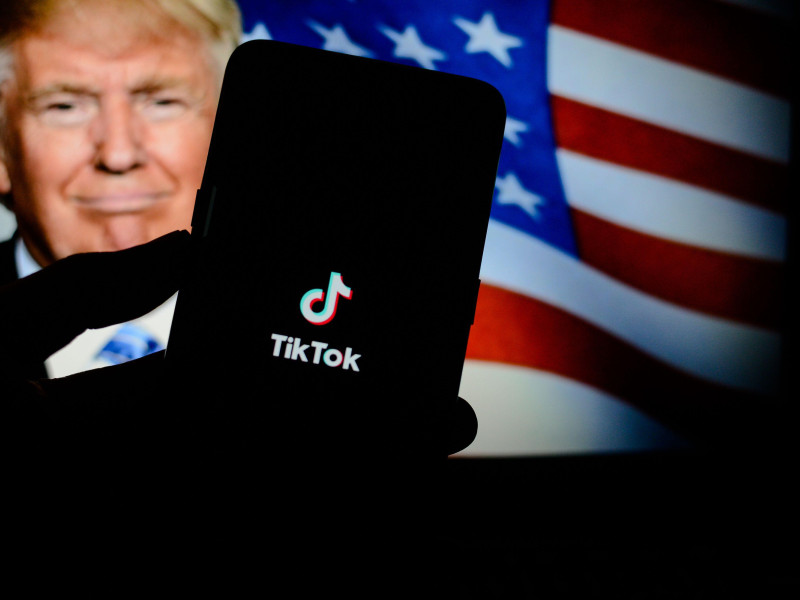 En esta ilustración fotográfica aparece el logotipo de la aplicación TikTok en un teléfono inteligente con el presidente de Estados Unidos, Donald Trump, y la bandera de los Estados Unidos.
