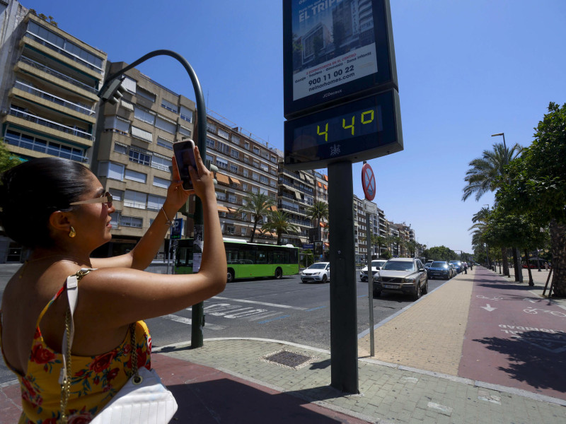 Una mujer fotografía un termómetro que marca 44 grados en Córdoba este sábado, una jornada marcada por la ola de calor que afecta a numerosas partes del país