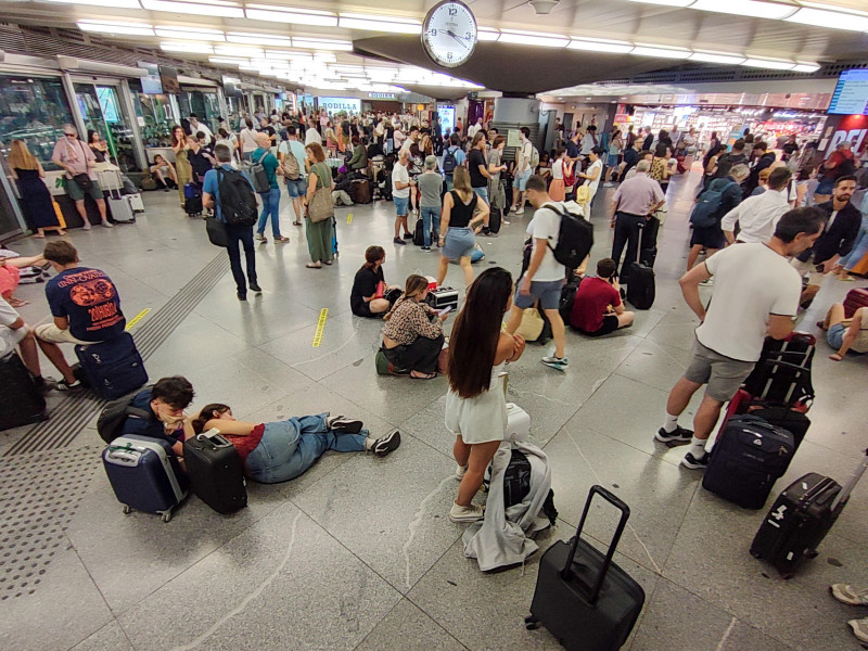 Cientos de personas esperan la salida de su tren en la estación de Atocha en Madrid