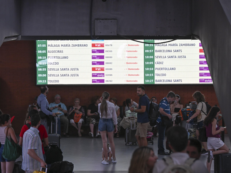 Varios pasajeros aguardan la salida de su tren en la Estación de Atocha