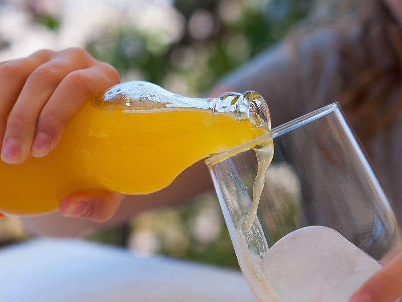 Un cliente tomando un refresco de naranja