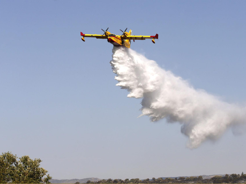 Un hidroavión descarga agua sobre un incendio