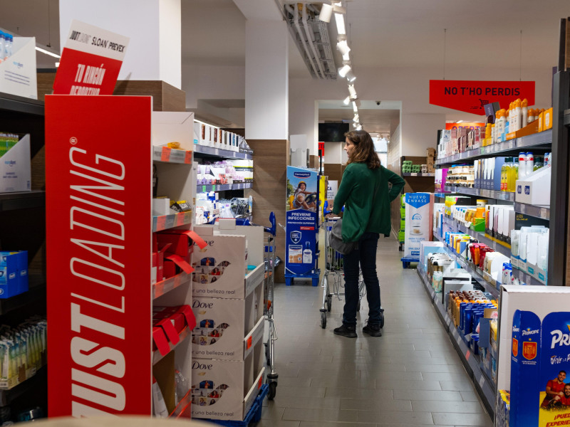 Uma mulher carrega uma cesta de compras em um supermercado Aldi.