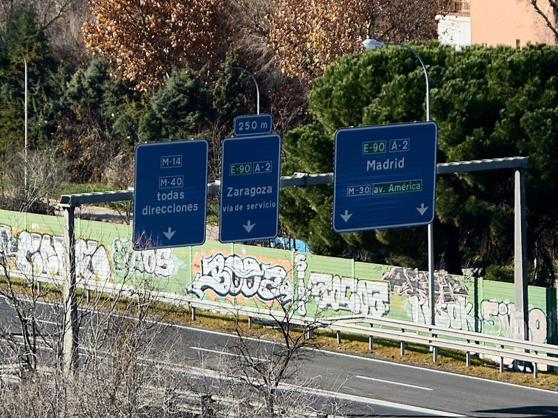 Señales de tráfico cerca de Madrid y Zaragoza con grafitis en los muros circundantes